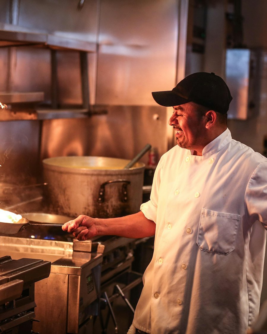 Chef in white uniform cooking on the pass in a professional kitchen
