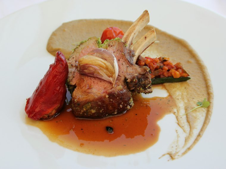 Grilled lamb chops plated with roasted pepper, purée and pan jus