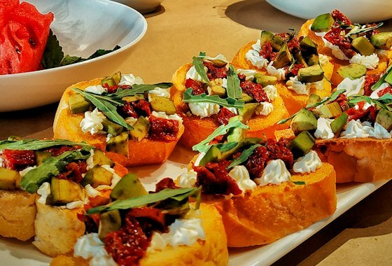 Canapés and topped crostini arranged on boards for a reception